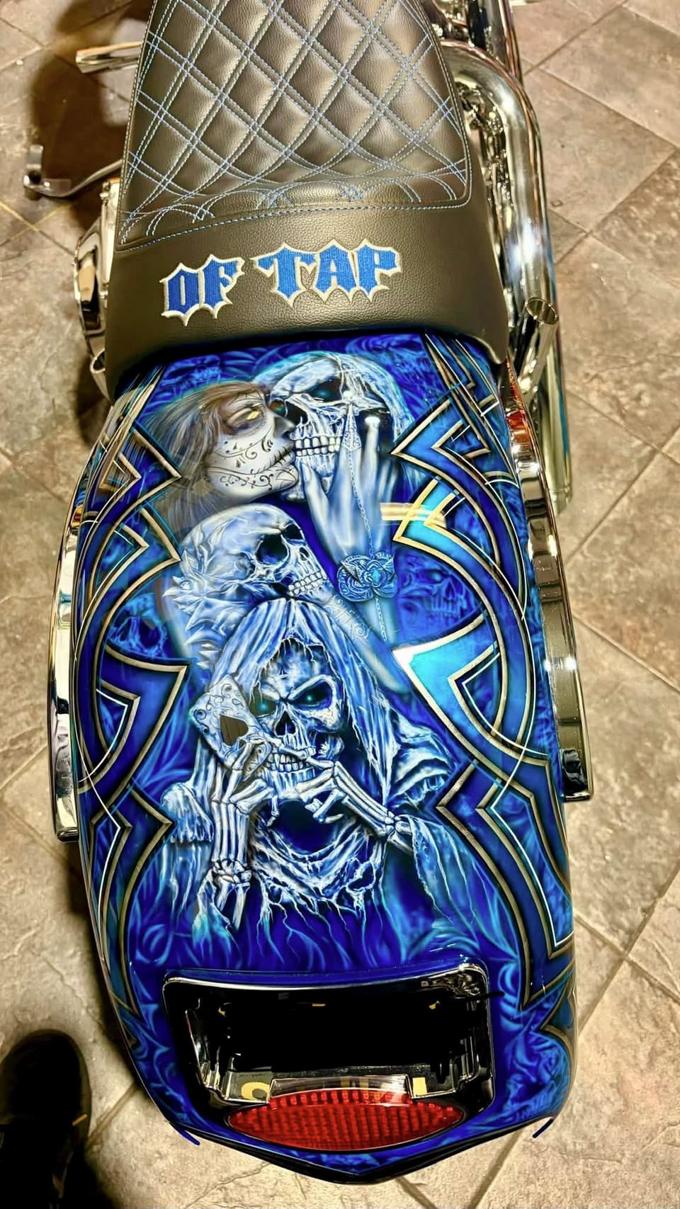 Airbrushed rear fender and diamond-stitched seat on a blue custom