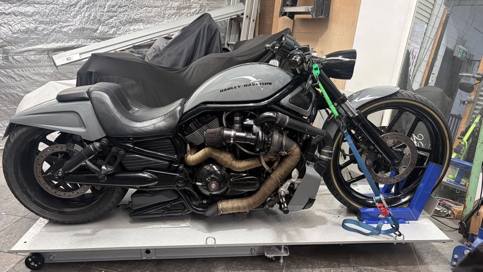 Grey Harley-Davidson V-Rod with wrapped exhaust, strapped to the lift