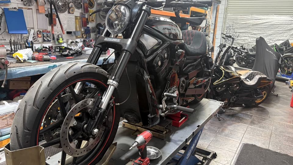 V-Rod with red-striped wheel rims on the lift