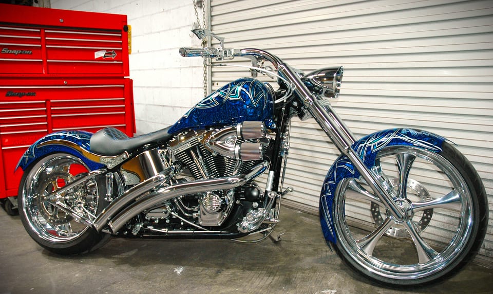 Blue custom motorcycle with chrome wheels and pinstriped bodywork in the Westside Cycles workshop